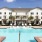 wide view of uniquely shaped swimming pool showing multiple reclining seats, spacious walking areas & nearness to the property