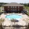 wide view of uniquely shaped swimming pool showing multiple reclining seats, spacious walking areas & nearness to the property