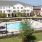 wide view of uniquely shaped swimming pool showing multiple reclining seats, spacious walking areas & nearness to the property